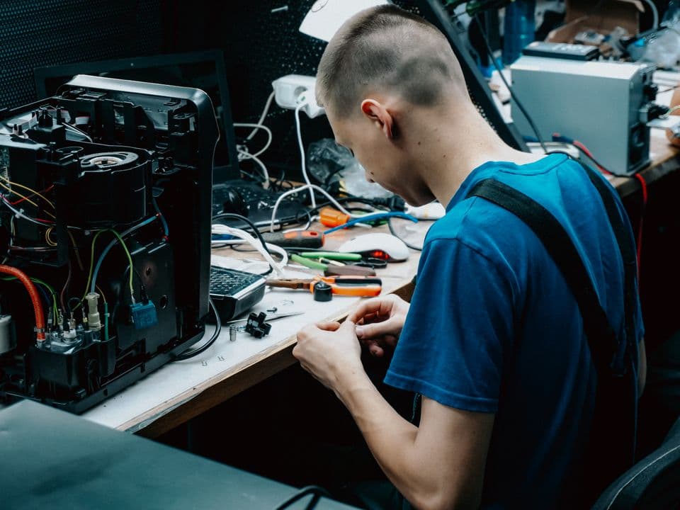 A technician repairing electronics at a workbench