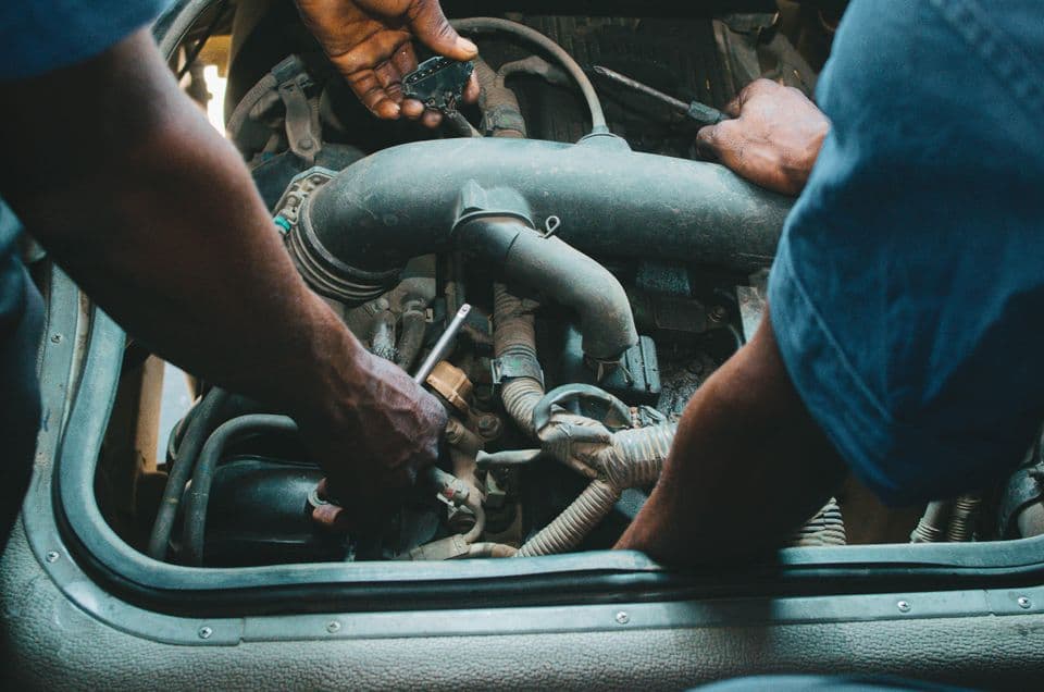 Mechanics working on a vehicle engine