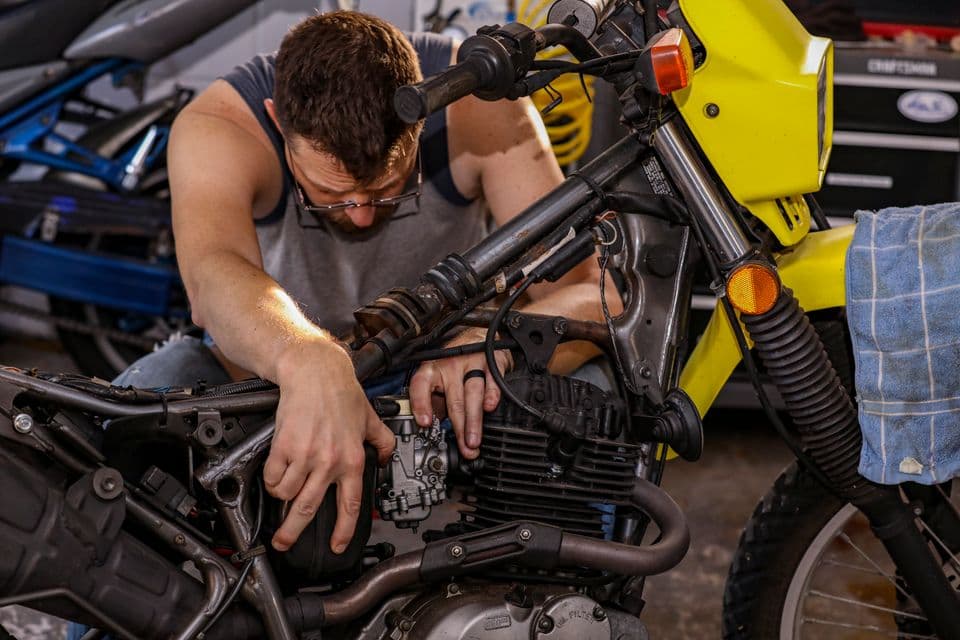 A mechanic repairing a motorbike