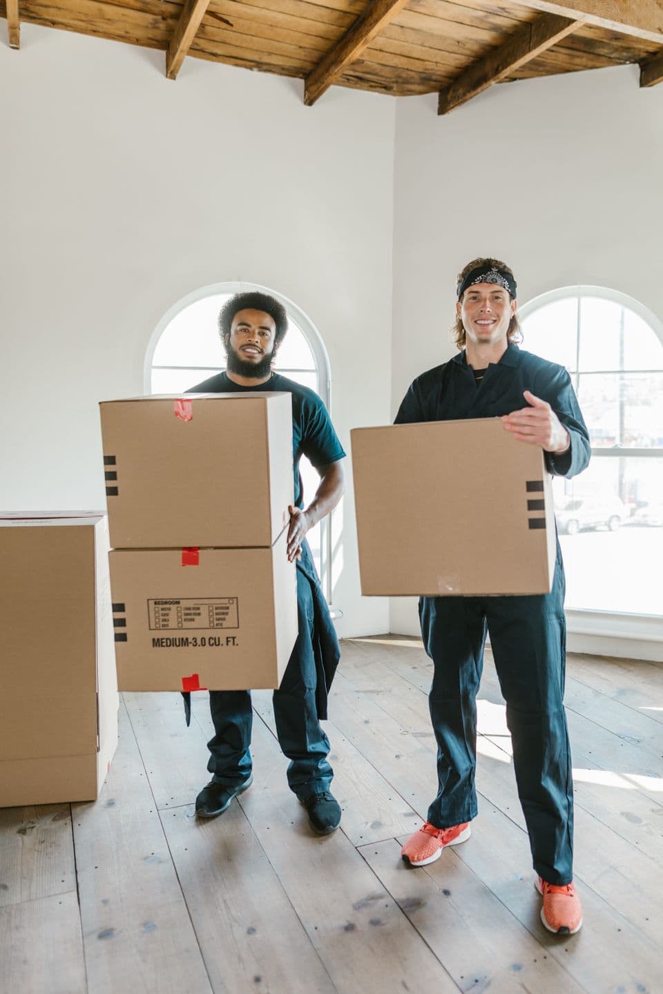 Two movers carrying cardboard boxes
